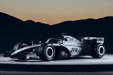 A Formula 1 race car featuring a split black and white design with a gradient pattern of repeating chevrons.