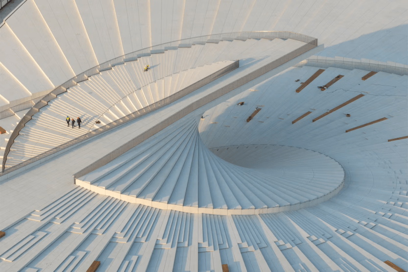 A sweeping riverside cultural building featuring an accessible rooftop and inviting public spaces.