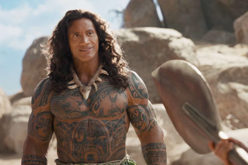 Dwayne Johnson as the demigod Maui holding his iconic fishhook next to Catherine Laga’aia as Moana in a stunning ocean environment.