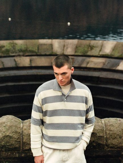 A model wearing a garment dyed sailing jacket from Stone Island Marina's SS26 collection, photographed at a working marina.