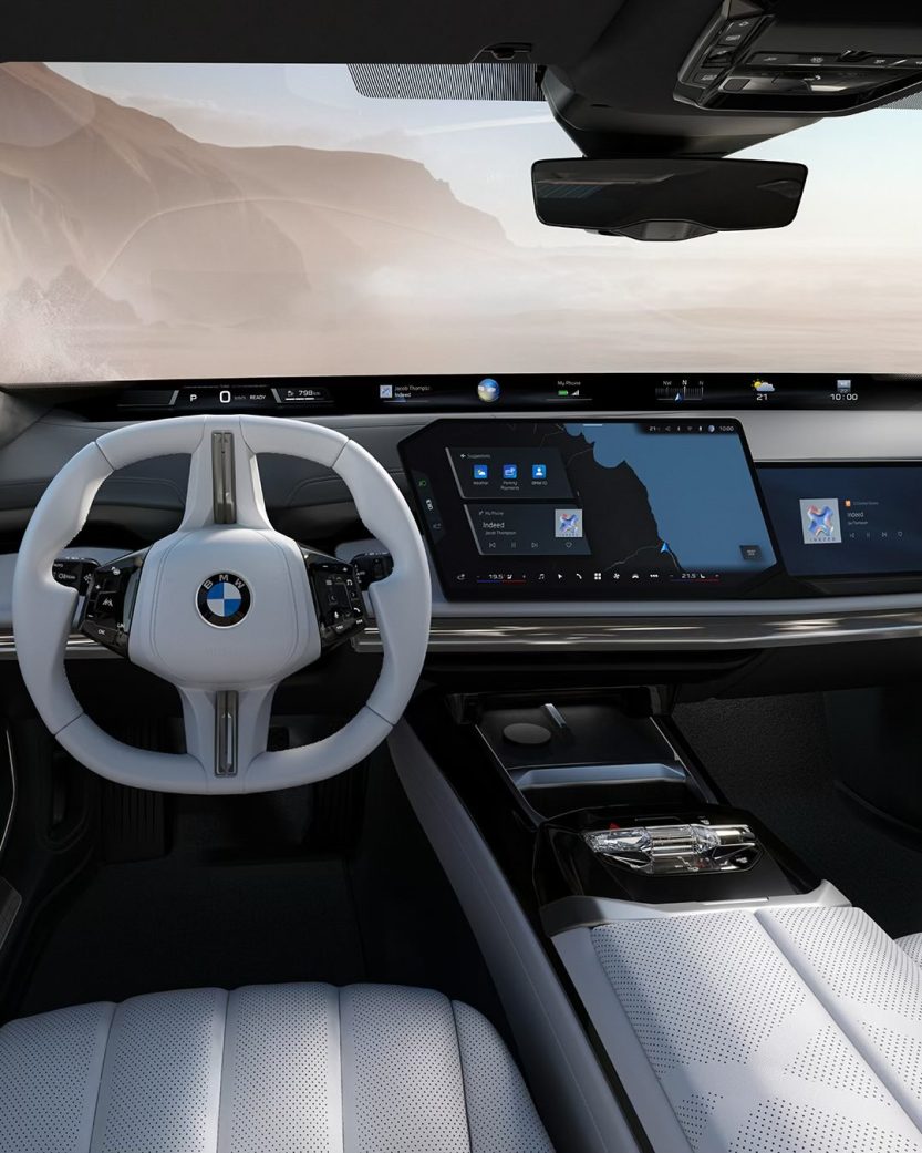 The 2027 BMW 7 Series interior showing the Panoramic iDrive system stretching across the base of the windshield alongside the 17.9-inch central touchscreen.